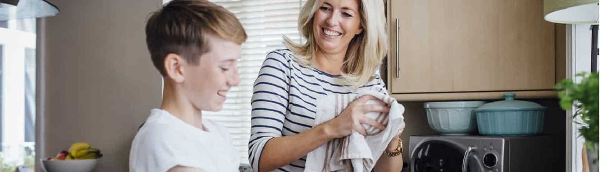 Jongen helpt mama bij afwas: klusjes voor kinderen