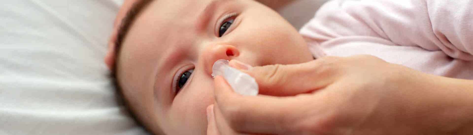 Baby met verkoudheid krijgt druppels in neus