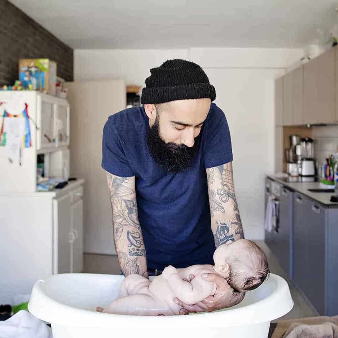 Papa wast baby in kinderbadje tijdens geboorteverlof