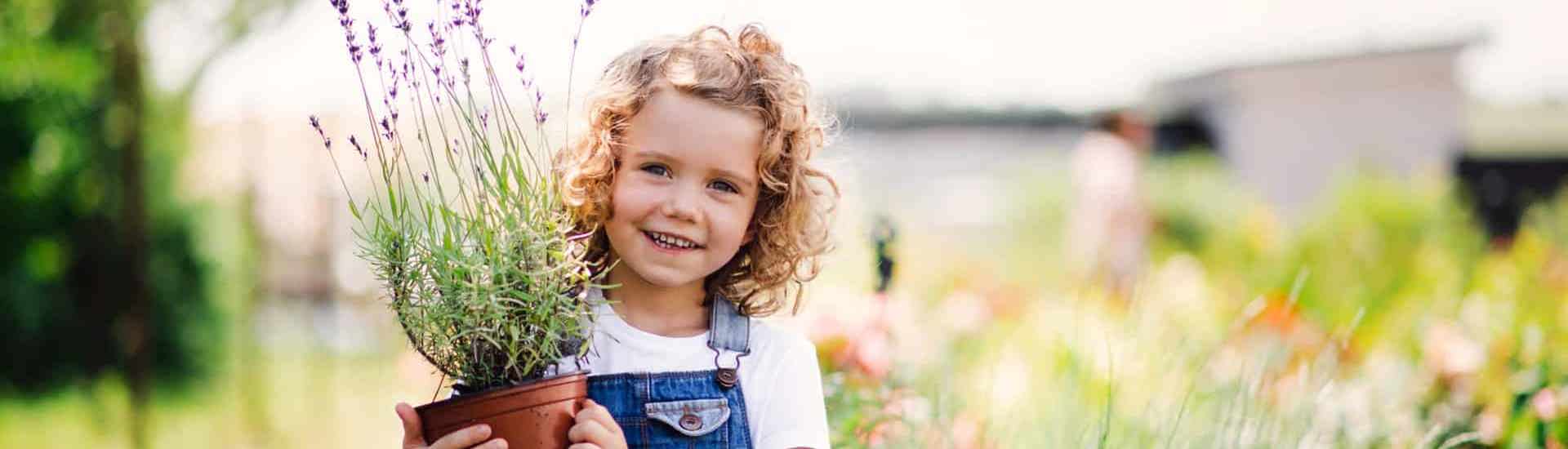Meisje met plant in de tuin: zo kan je water besparen in de tuin