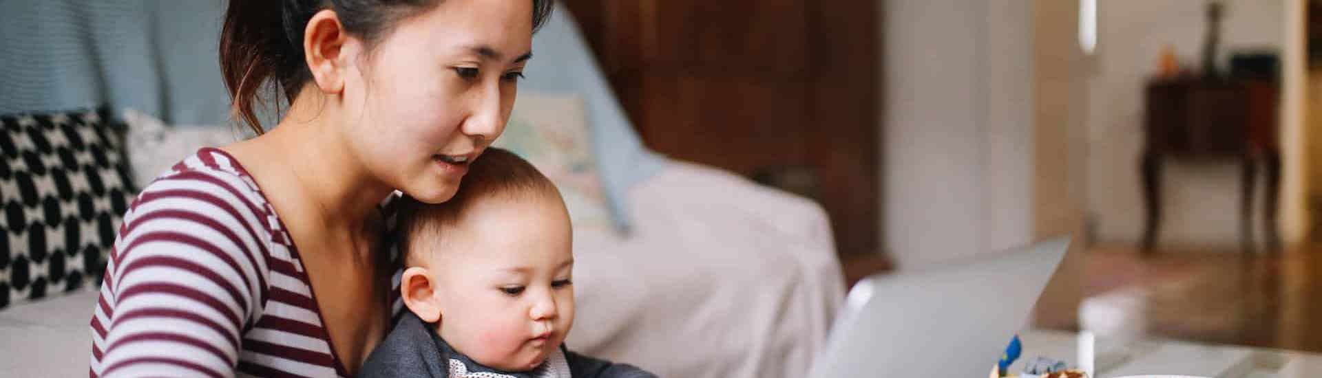 Mama en baby achter computer: over opvoedbijbels van vroeger en nu