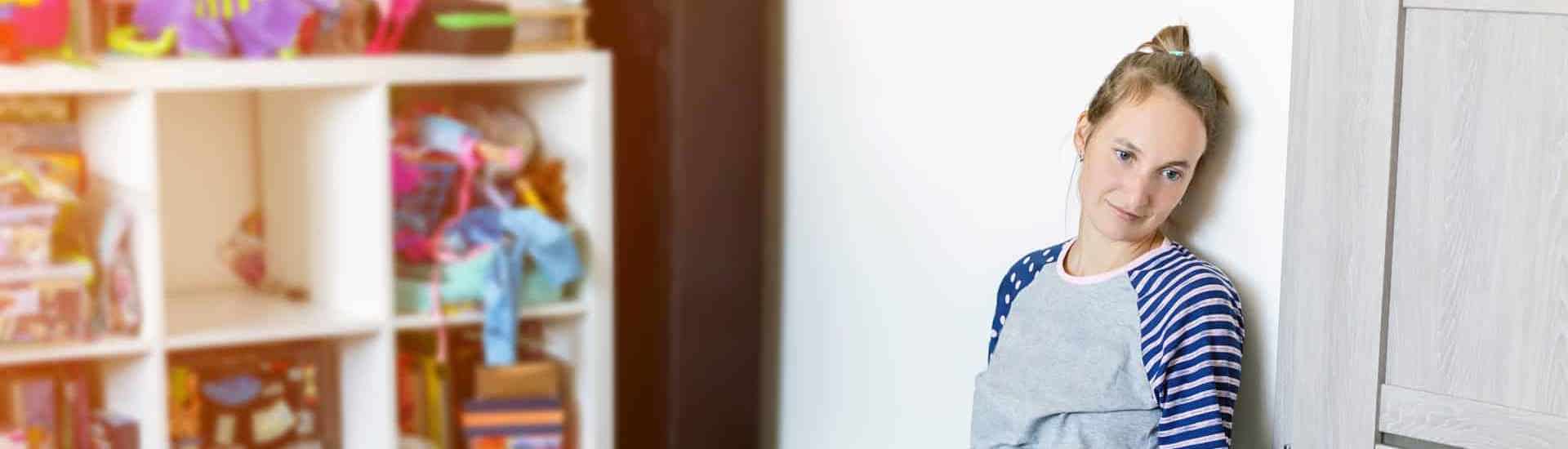 Vermoeide mama kijkt naar spelende baby: zo slaap je meer