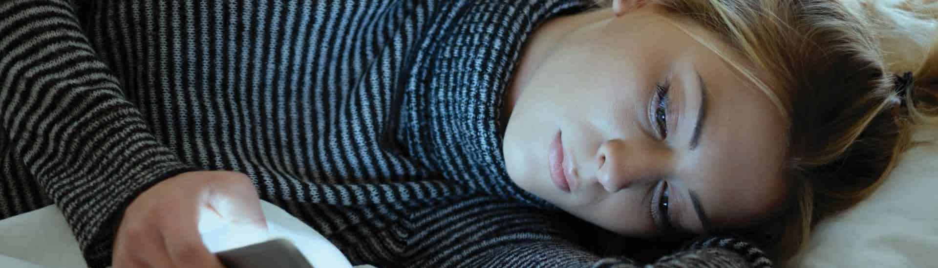 Tiener met smartphone in bed: Tieners en sociale media