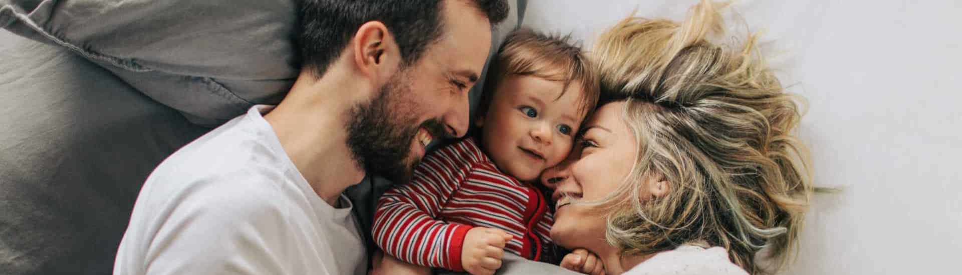 Koppel met baby in bed: voor de eerste keer ouder