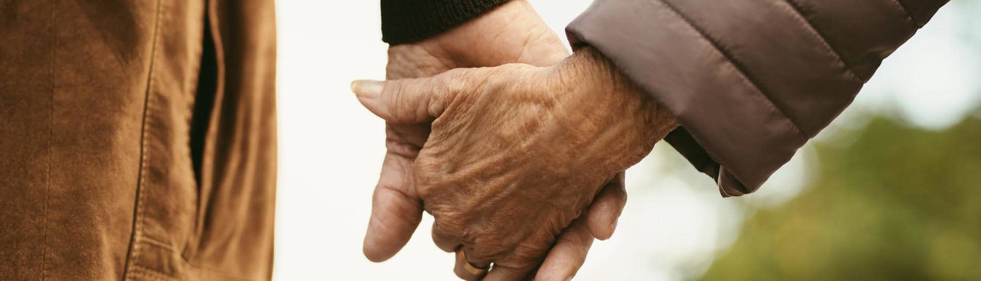Ouder koppel wandelt hand in hand: zo hou je de vonk in langdurige relaties