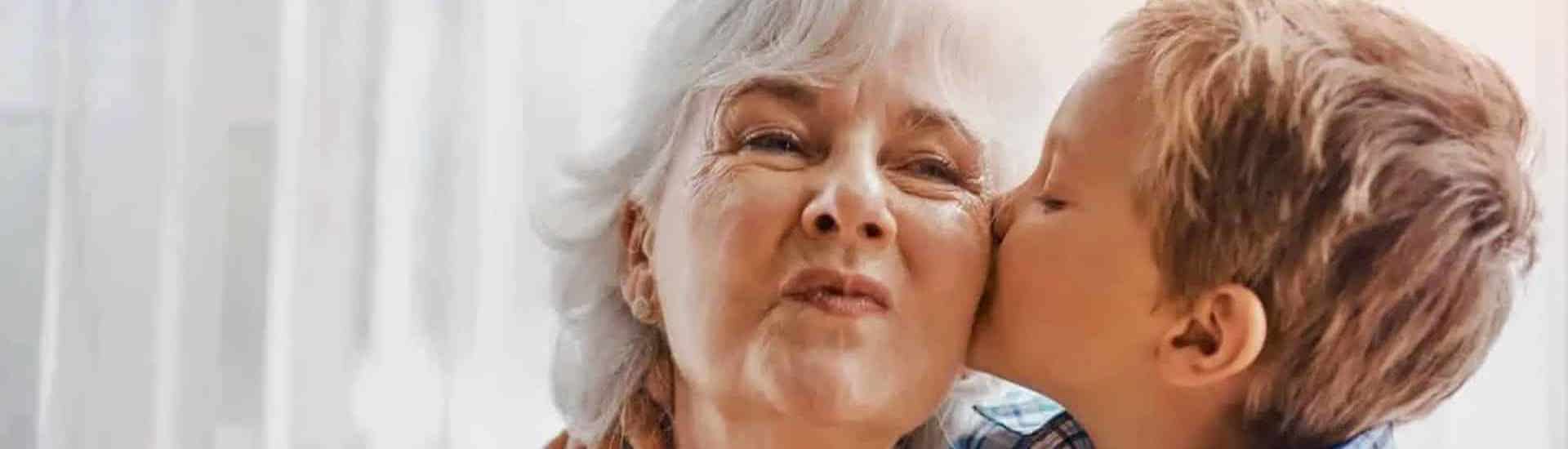 Kleinkind geeft een kusje aan oma: hoe stel je grenzen aan de opvang van kleinkinderen?