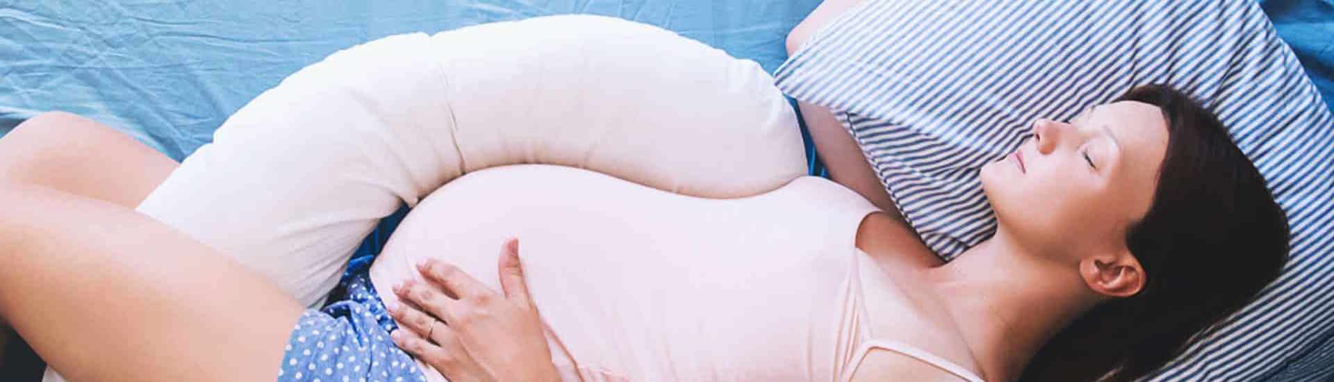 zwangere vrouw met zwangerschapskussen: slapen met bekkenpijn