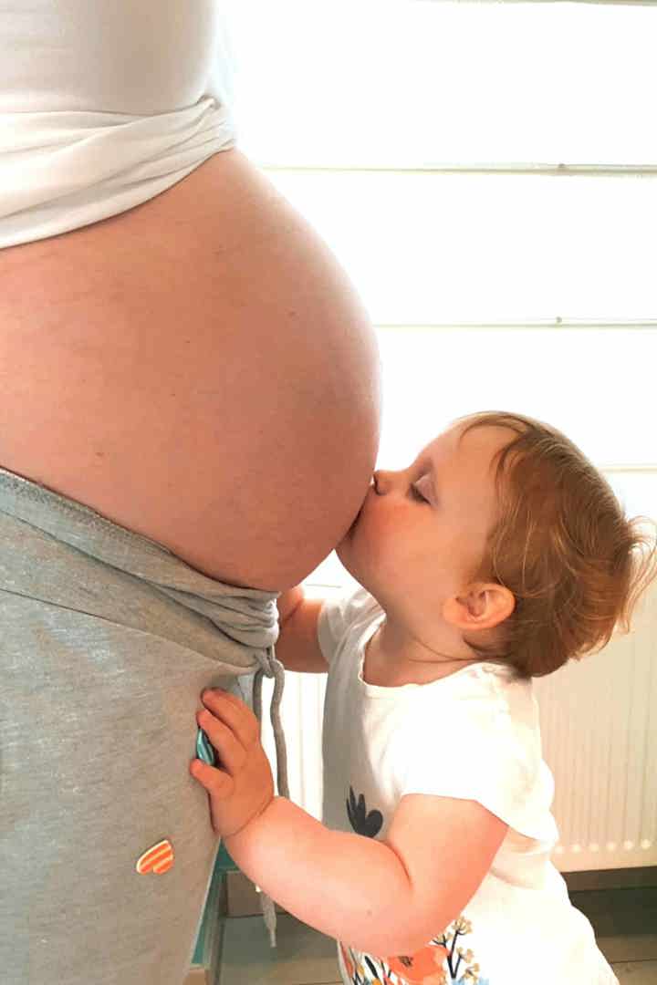 Peuter kust zwangere beuk van mama: gezond zwanger zijn