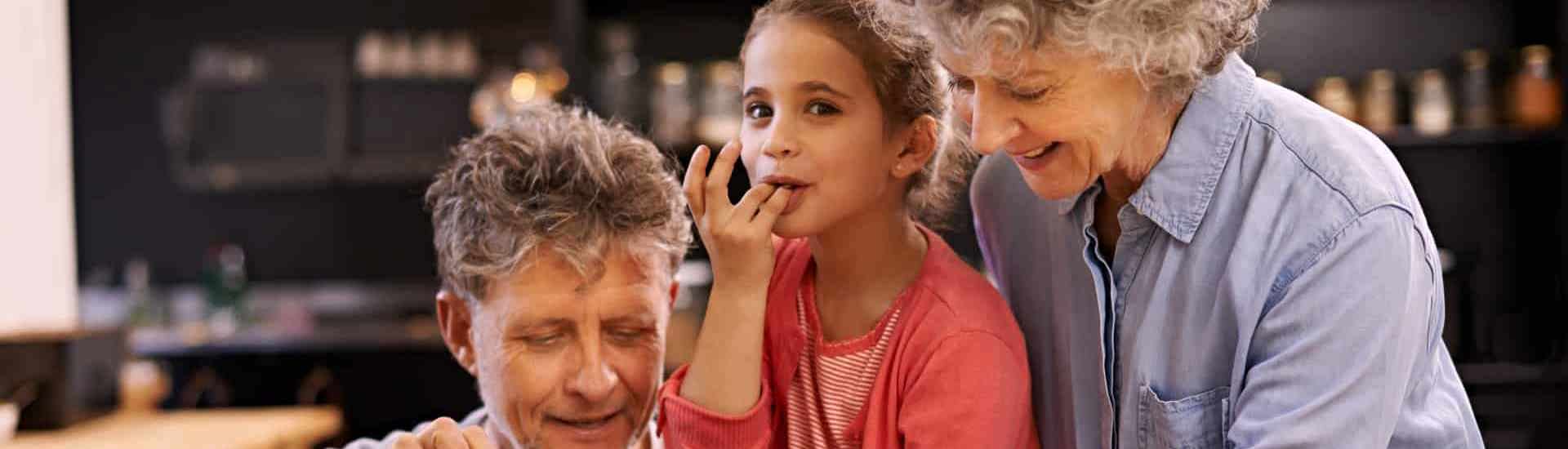 Grootouders en kleinkind snoepen chocolade
