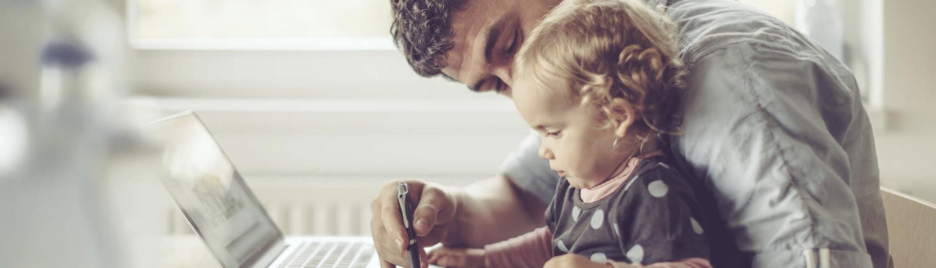 Papa en kind aan computer: budget eerlijk verdelen als samengesteld gezin