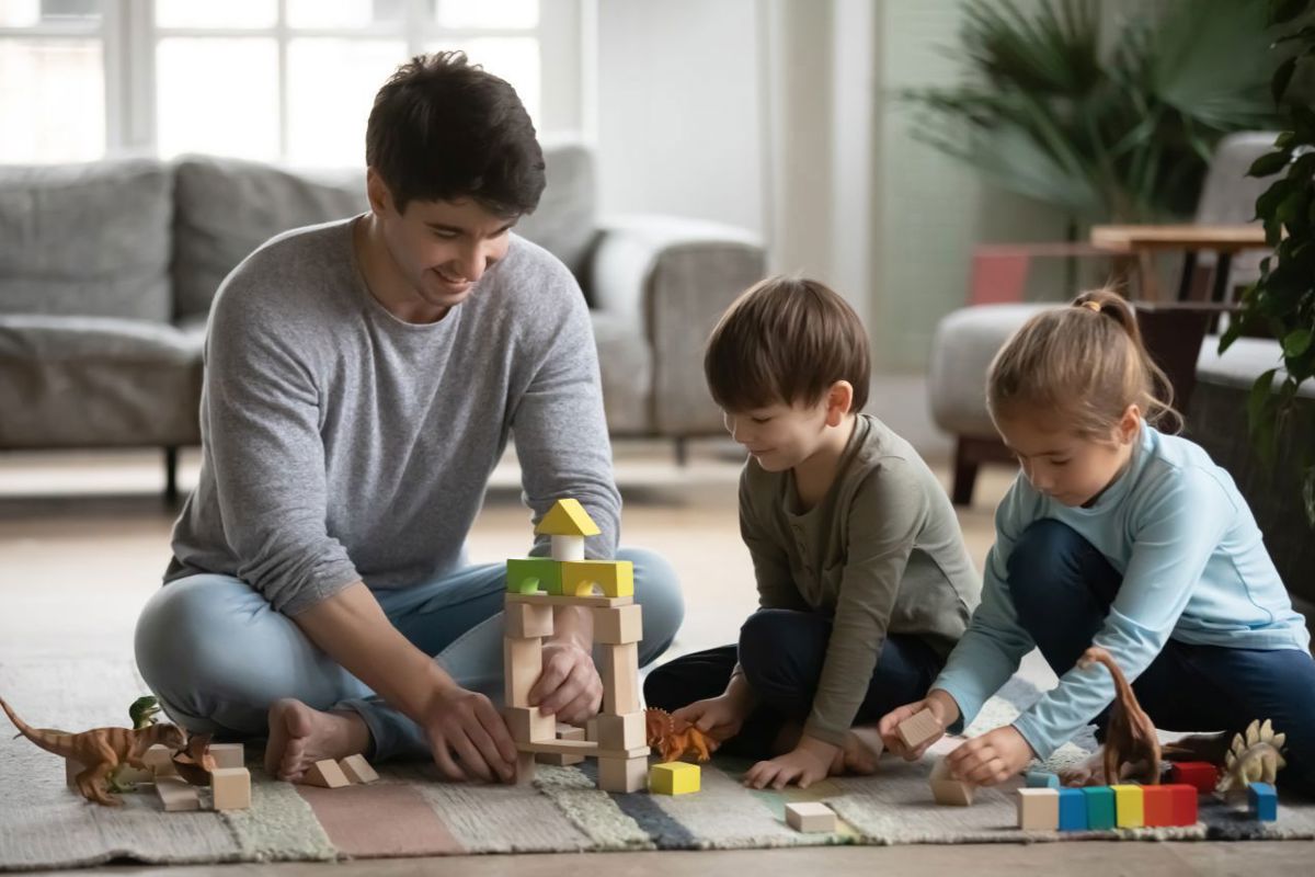 Gezinsbond papa en kinderen spelen met blokken
