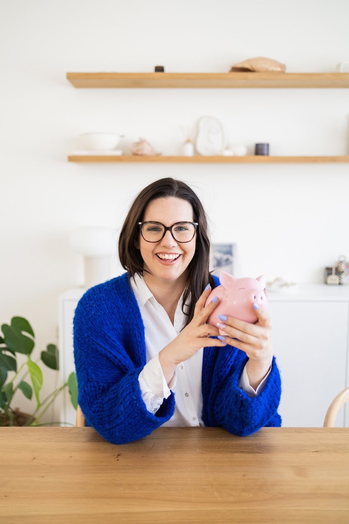 Vrouw met spaarvarken: tips van budgetcoach Djennah Van Nieuwenhove voor je gezisnbudget