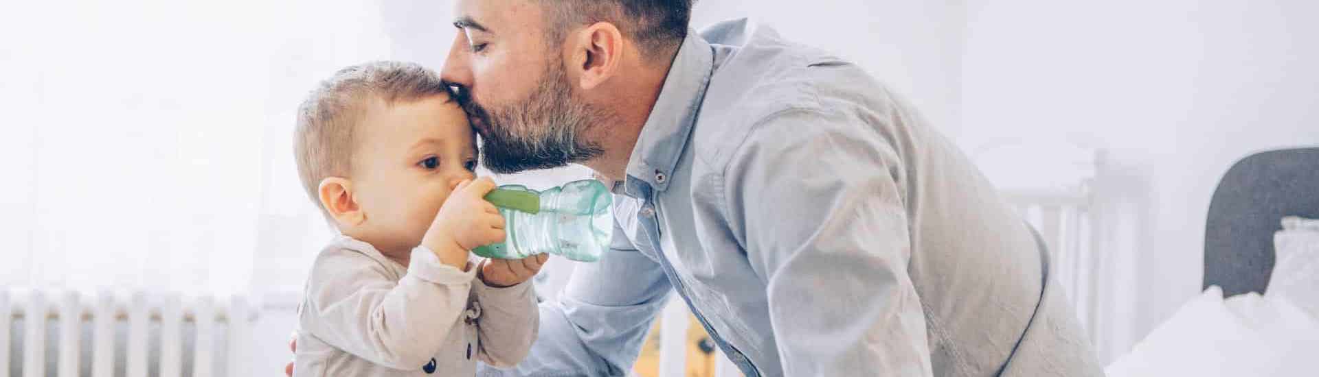Baby drinkt water met papa