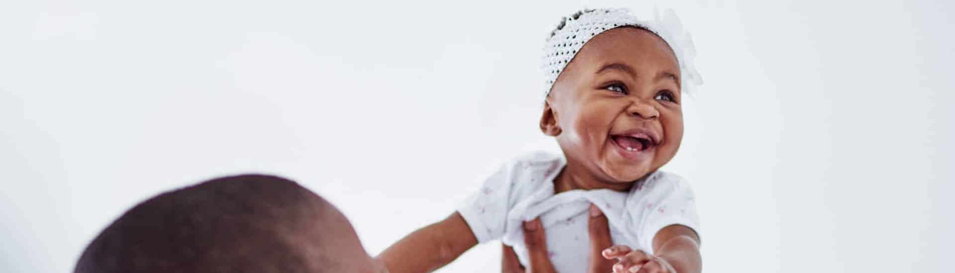 Mama tilt lachende baby omhoog