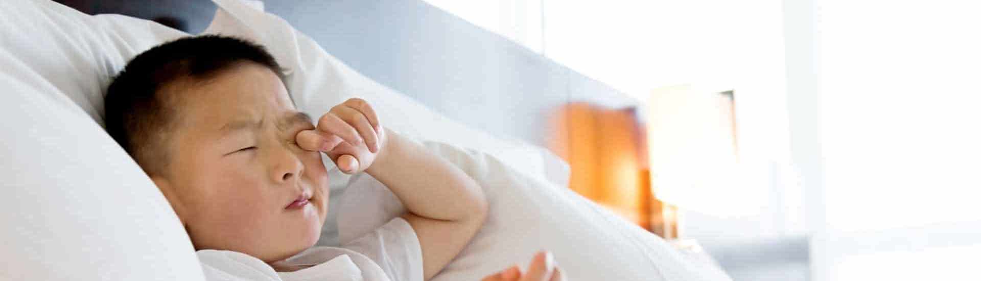 Kind ligt in bed en wrijft in de ogen: hoe weet je of je kind voldoende slaapt?