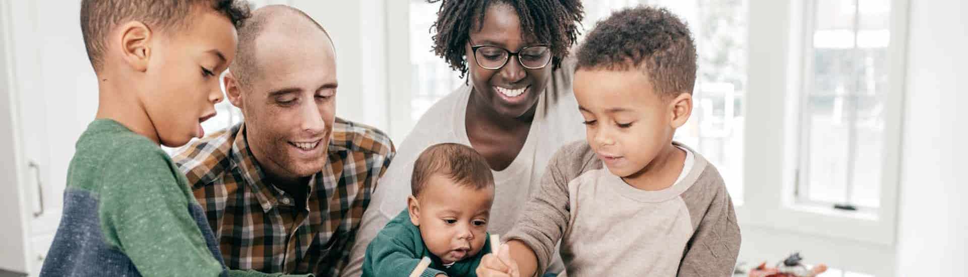 Familie maakt samen pakje open: opvoeden en straffen zonder straffen en belonen