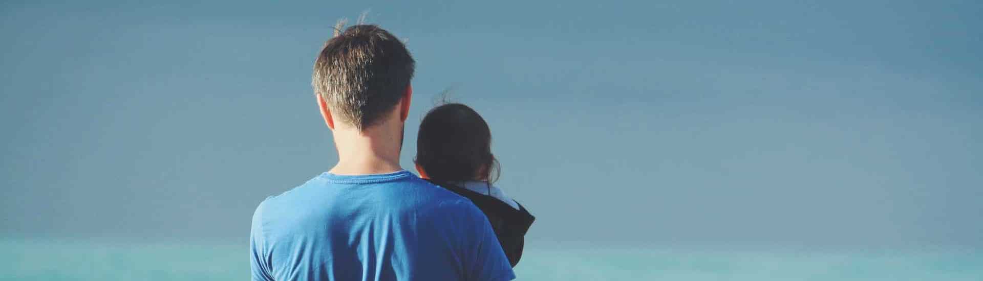 Alleenstaande papa met kind kijken naar de zee: het overlevingspensioen