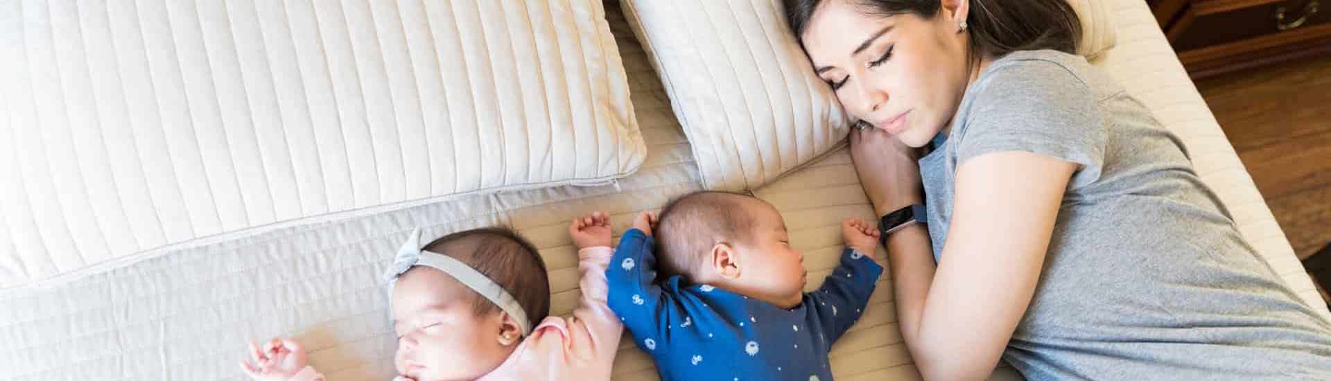 Mama met tweeling in bed: een half jaar handen te kort
