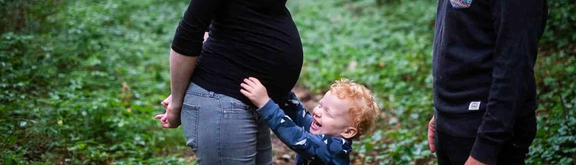 Kindje voelt aan zwangere buik van mama