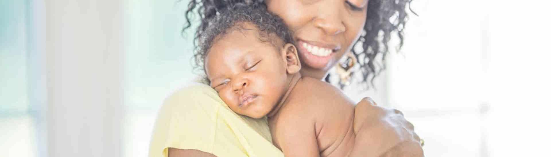 Mama met slapend kindje: slapen bij baby's
