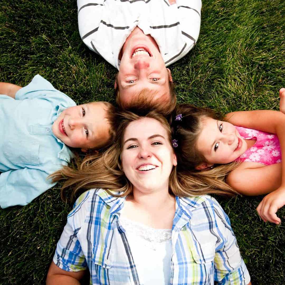 Kinderen en babysitter liggen in het gras: voorbereiden op babysit