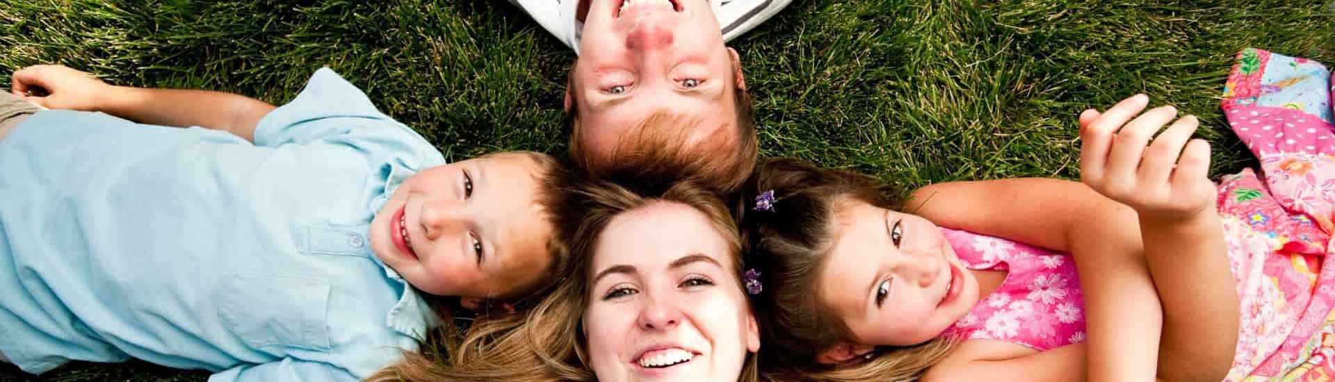 Kinderen en babysitter liggen in het gras: voorbereiden op babysit
